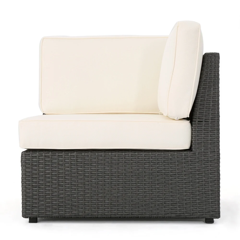Dark grey wicker outdoor sectional chair with plush ivory cushions