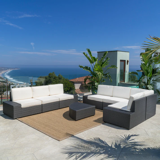 Dark grey wicker sectional sofa with white cushions perfect for patio lounging