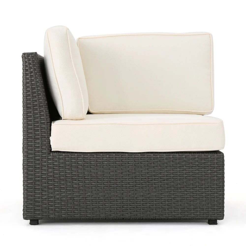 Dark gray rattan corner chair with plush cream cushions perfect for outdoor patios