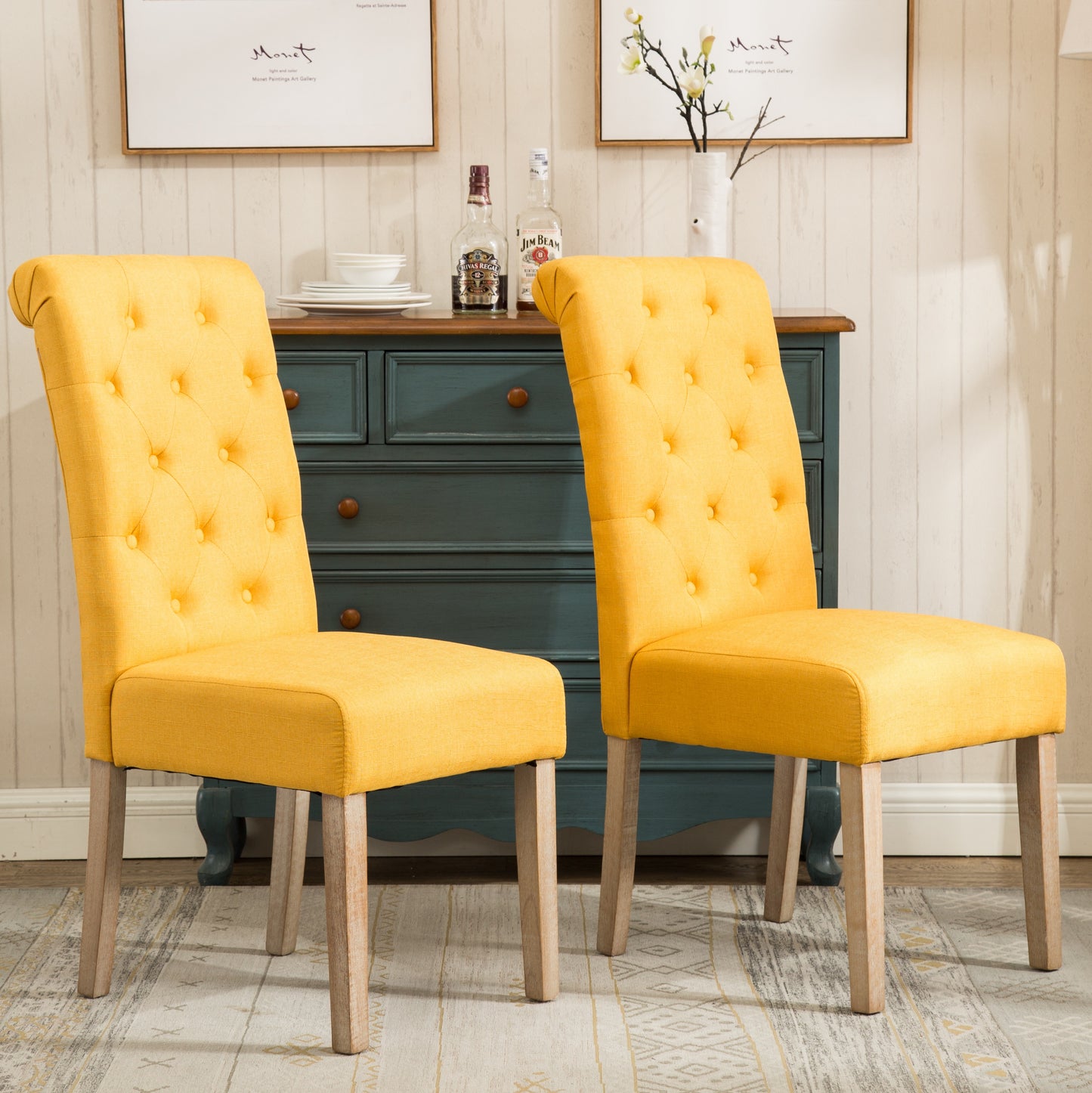 Two yellow linen dining chairs with button tufting and wooden legs