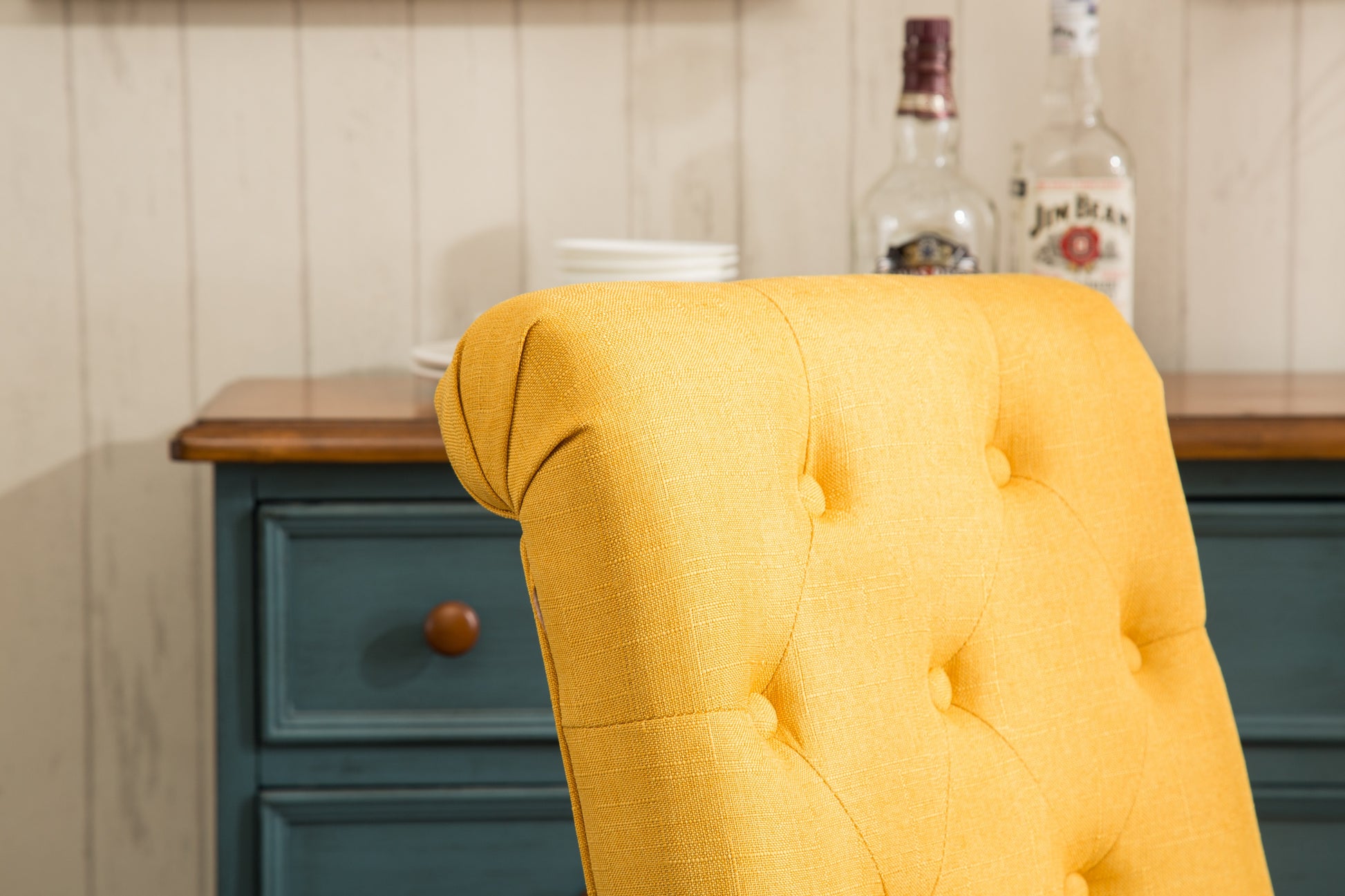 Yellow upholstered accent chair with tufted details and wooden legs perfect for living rooms