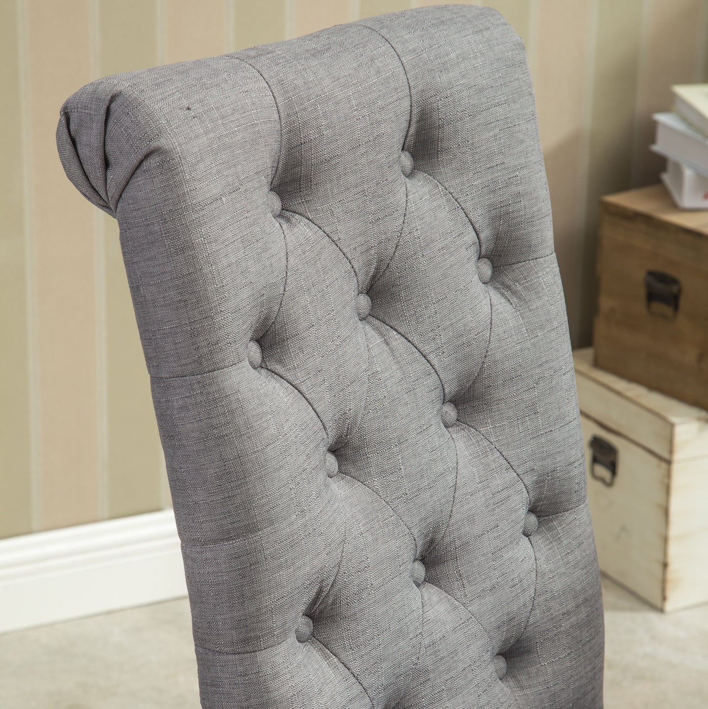 Closeup of a grey fabric tufted dining chair back showcasing textured weave