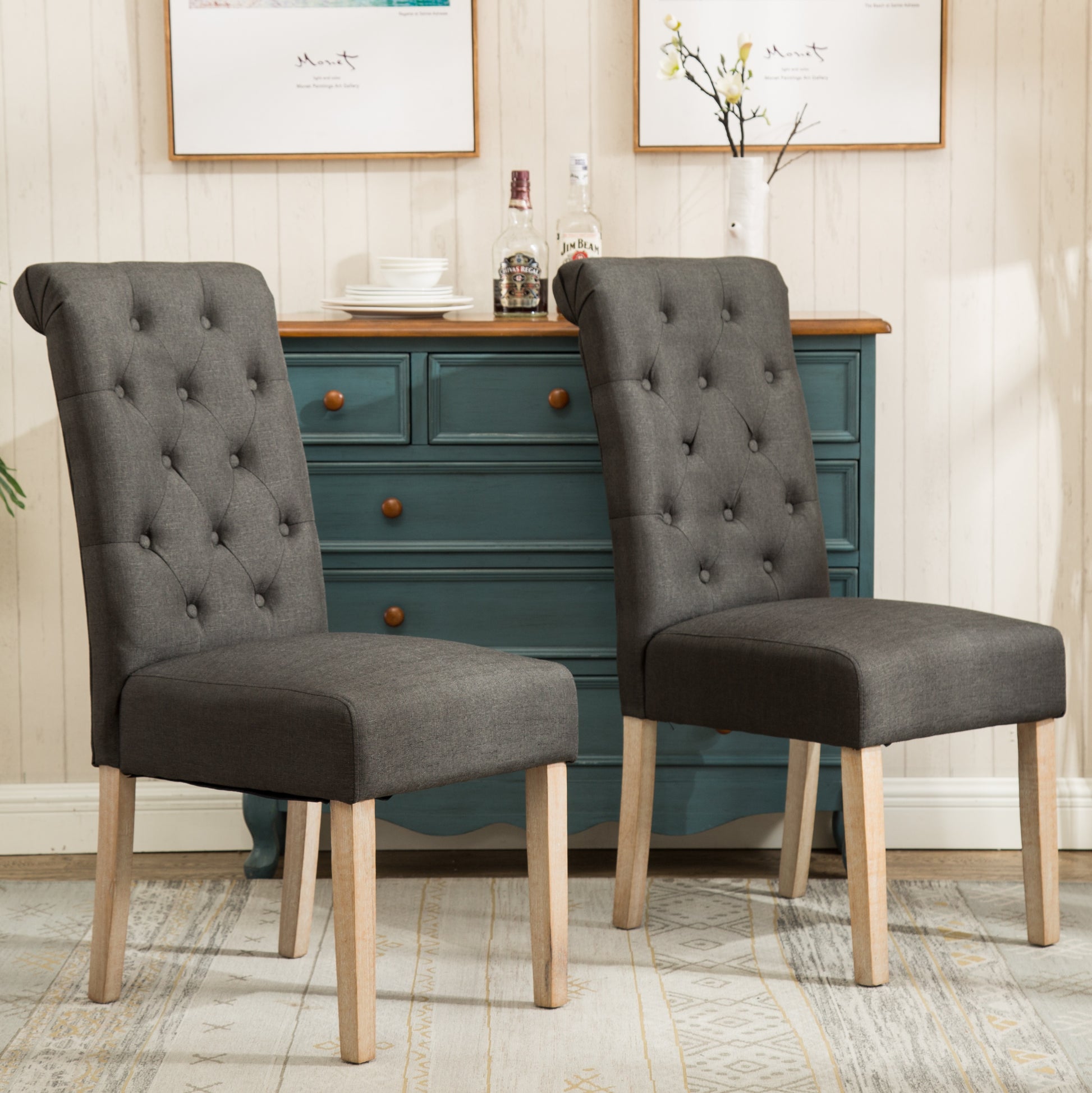 Dark grey fabric dining chairs with button tufting and wooden legs