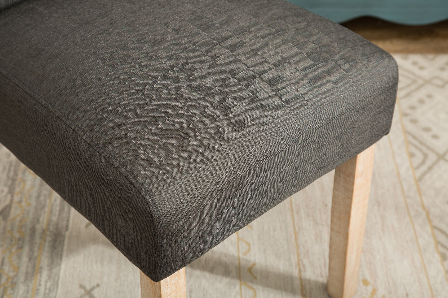 Dark gray upholstered seat cushion with visible linen texture and light wood leg