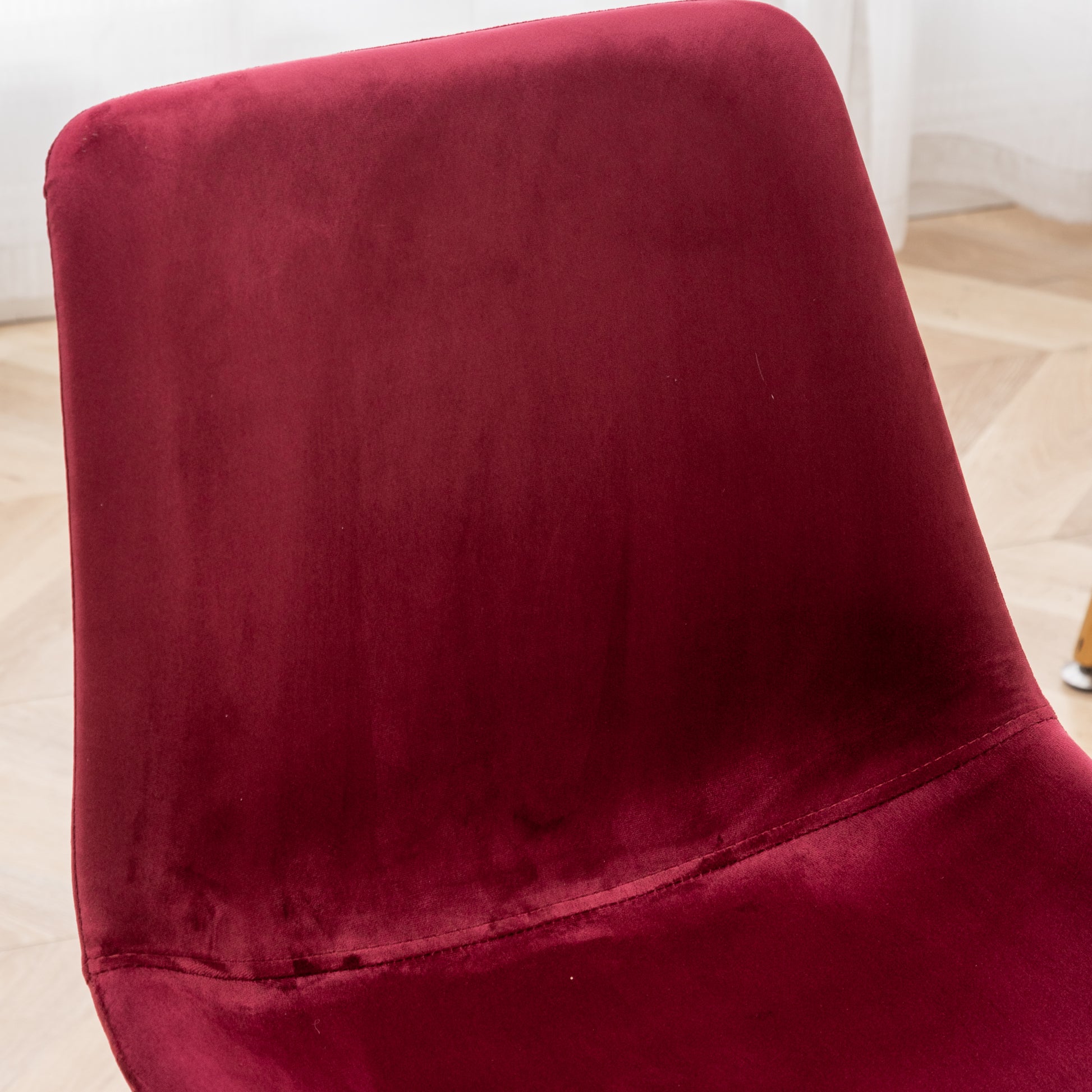Deep red velvet upholstery on a modern accent chair plush and inviting
