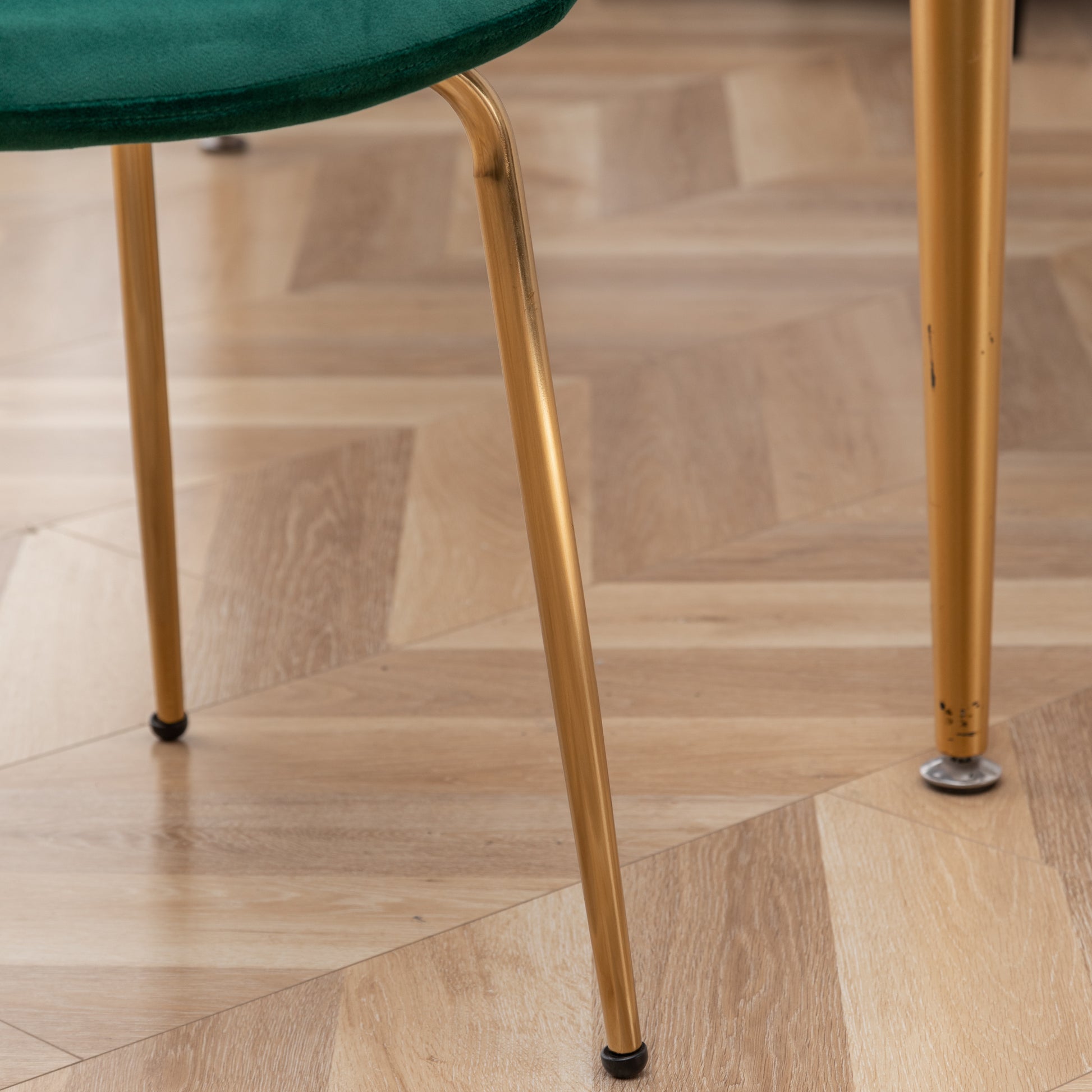 Emerald green velvet chair seat detail with gold metal legs