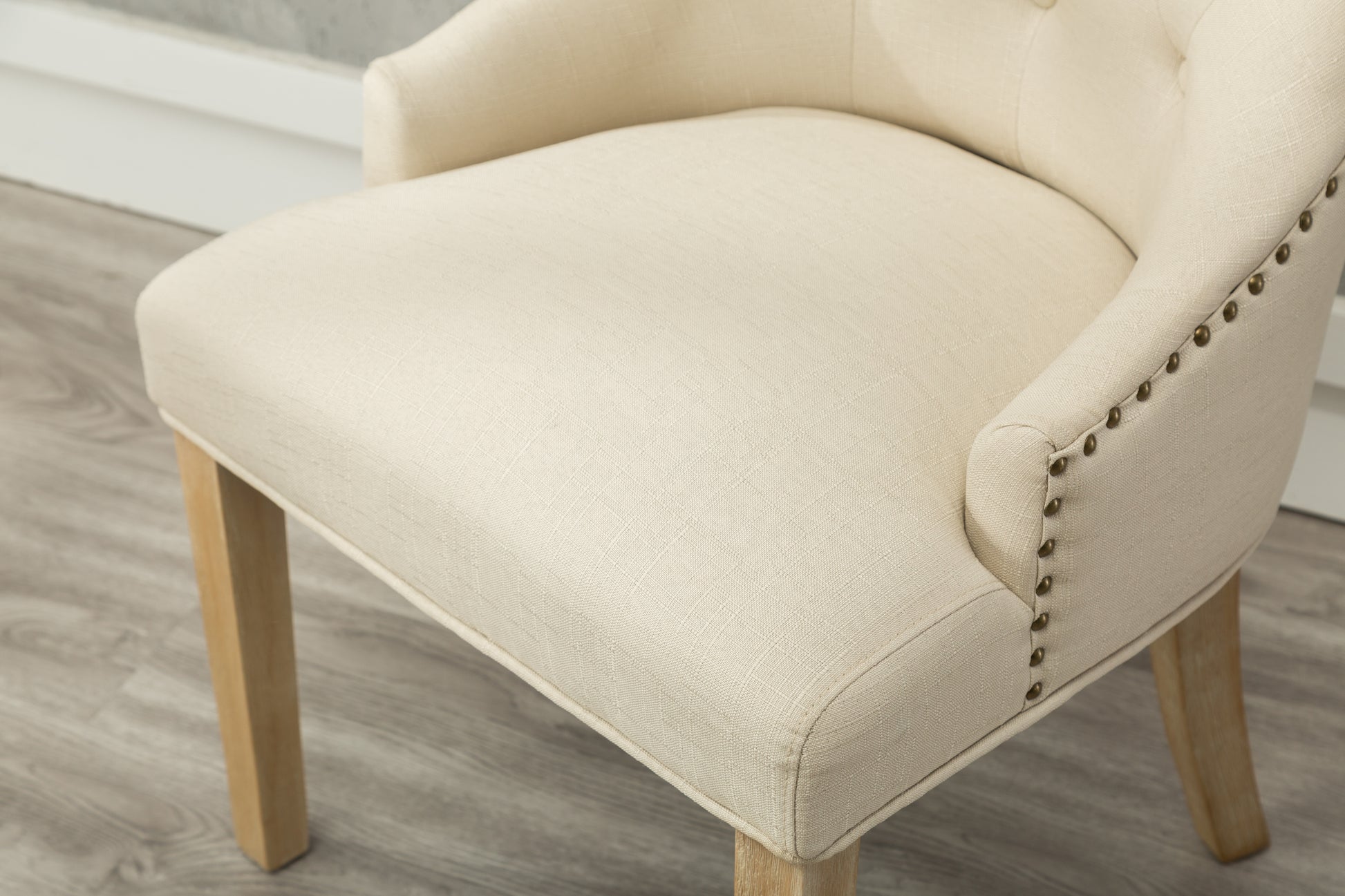 Cream linen upholstered accent chair with nailhead trim detail