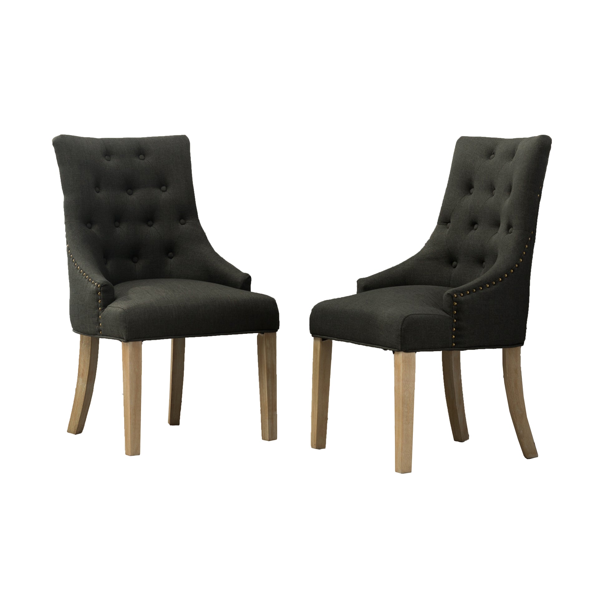 Two dark grey tufted dining chairs with brass nailhead trim and wooden legs
