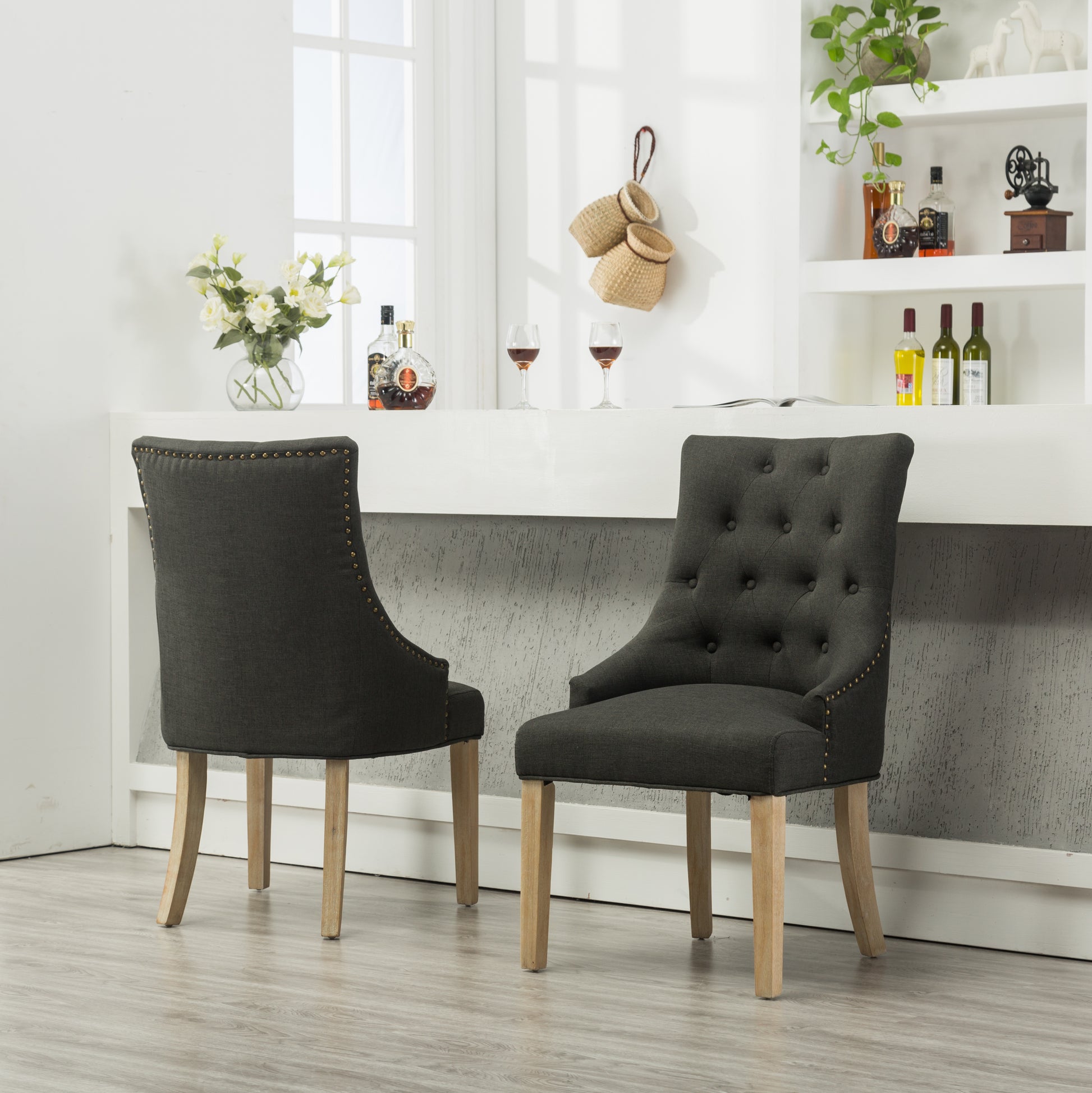 Dark gray linen upholstered dining chair with brass nailhead trim and tufted back