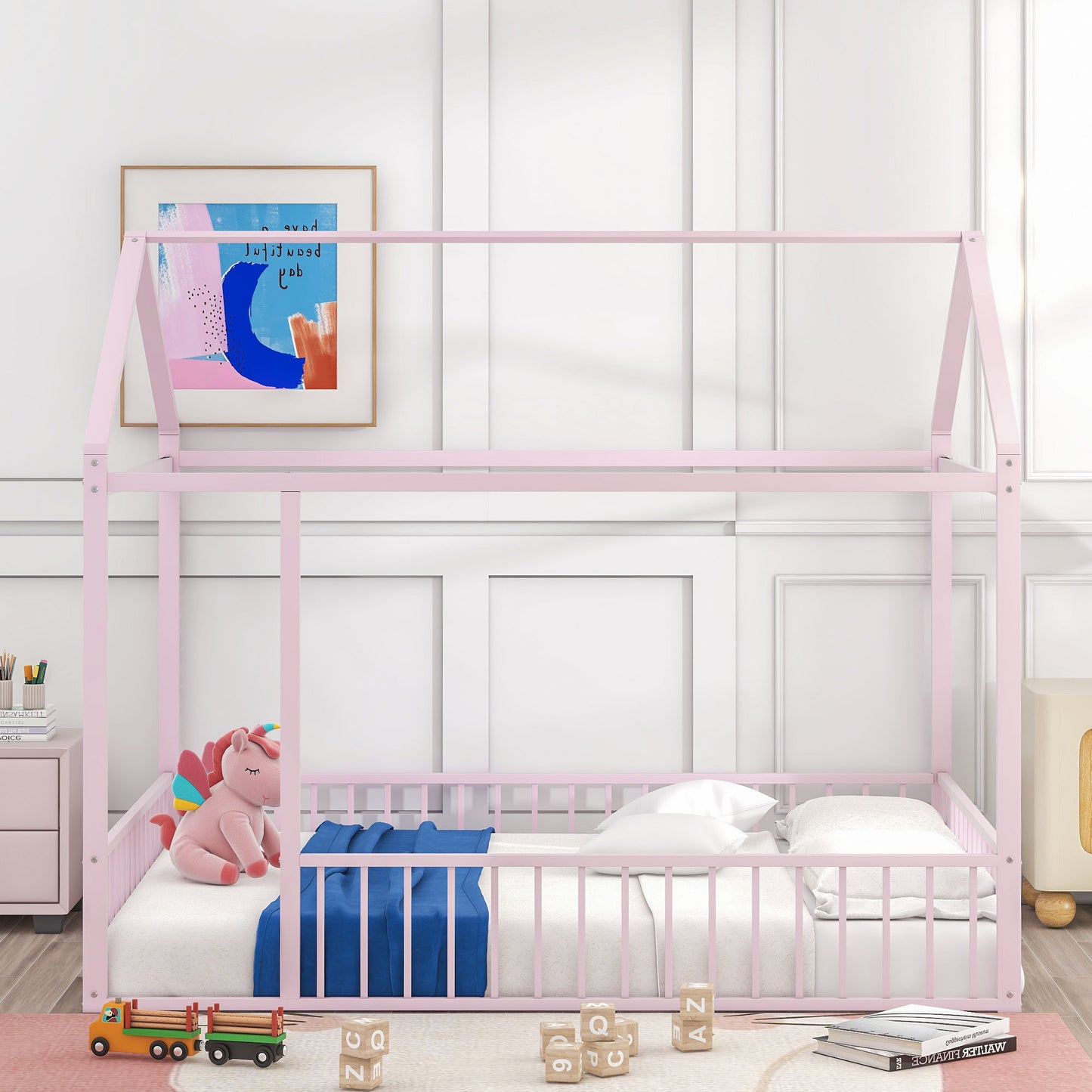 Pink metal house bed frame with playful unicorn toy and blocks