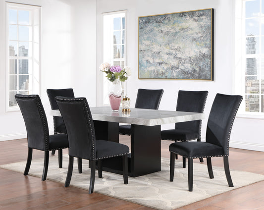 Black velvet dining chairs with nailhead trim surrounding a marbletop table