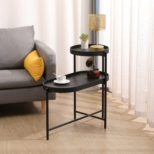 Black metal tiered side table with oval trays holding decorative items