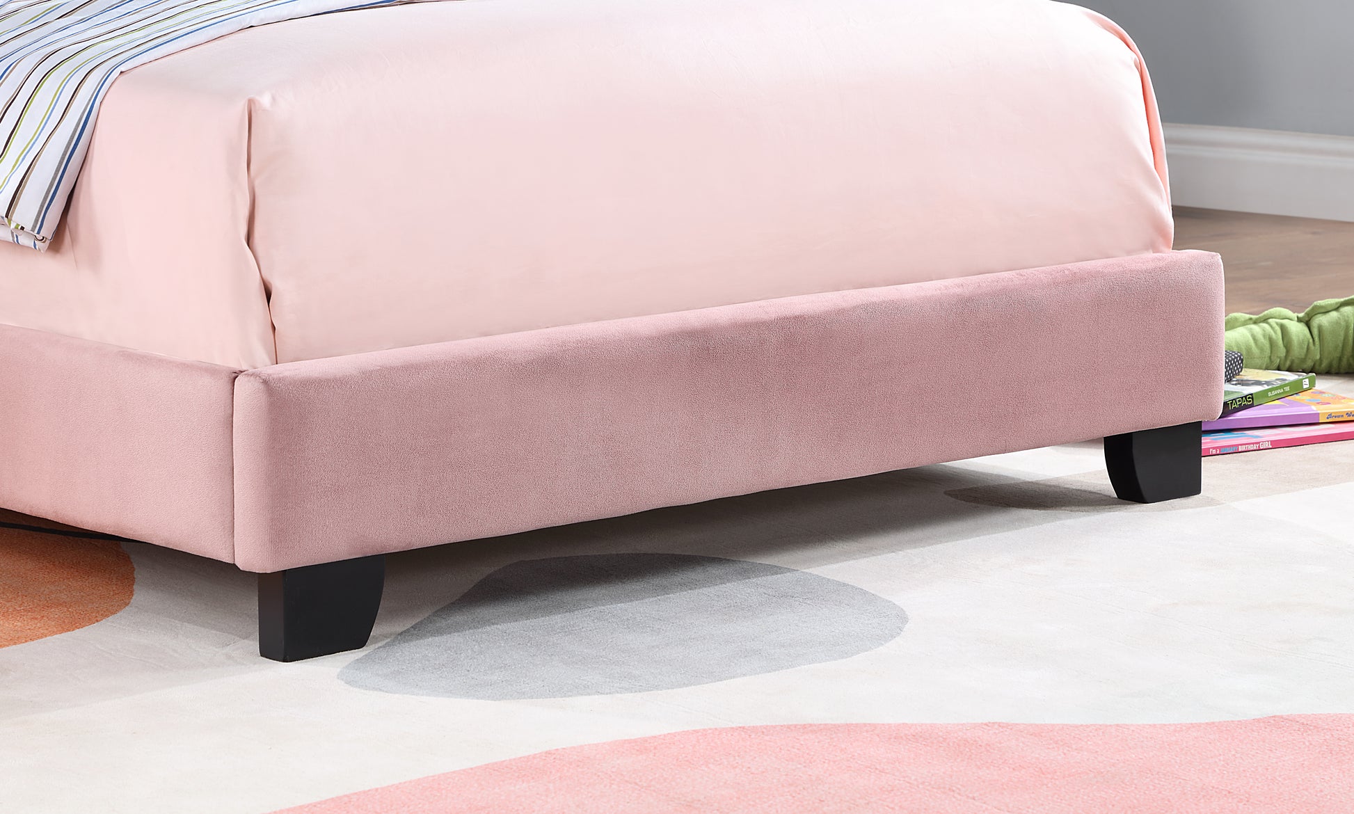 Pink velvet bed frame with black wooden legs