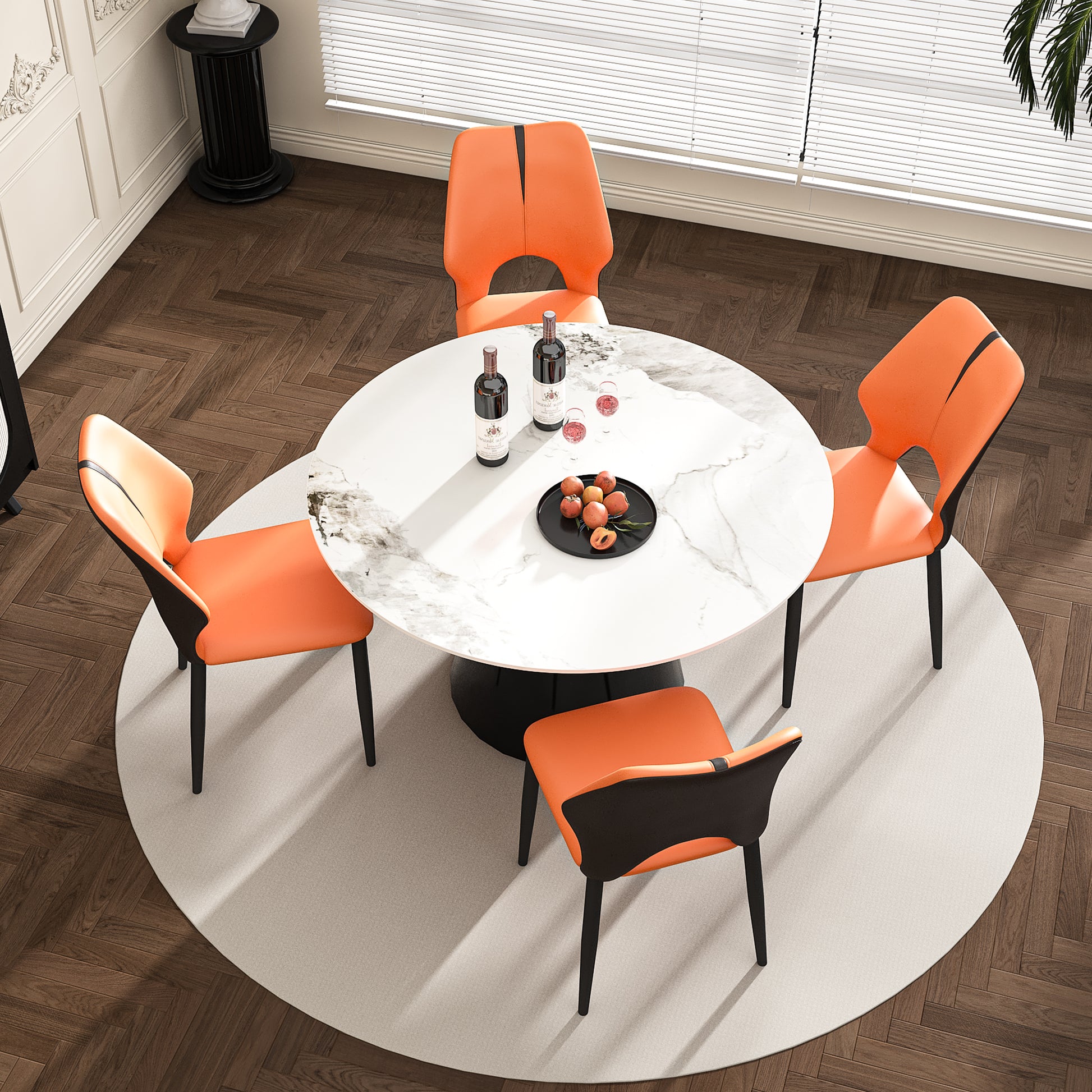 Round white marble dining table with four orange chairs