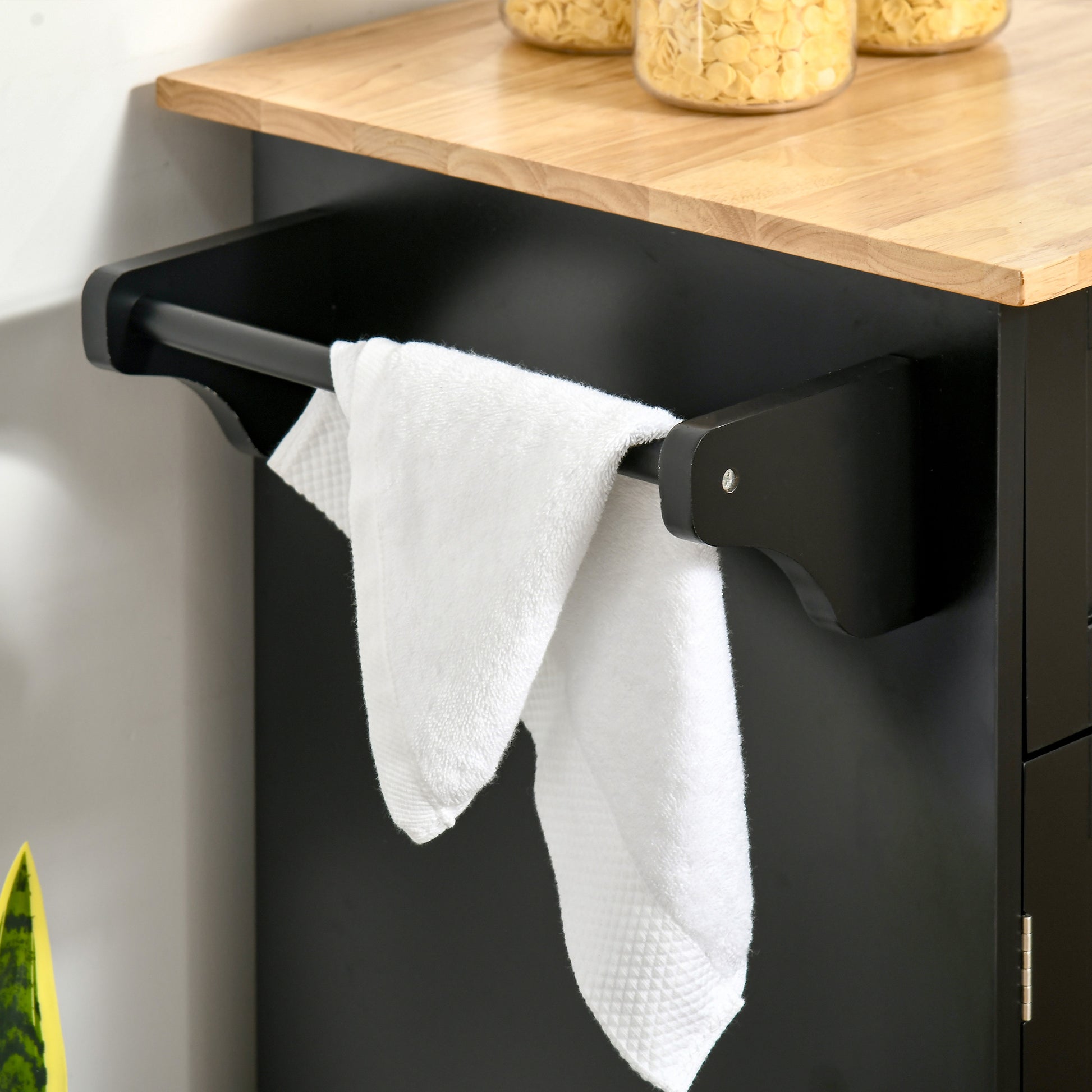 Black kitchen cart with wooden countertop and two white towels hanging on a bar