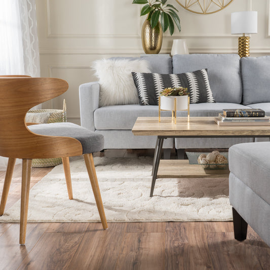 Light blue modern sofa with decorative pillows and a textured rug
