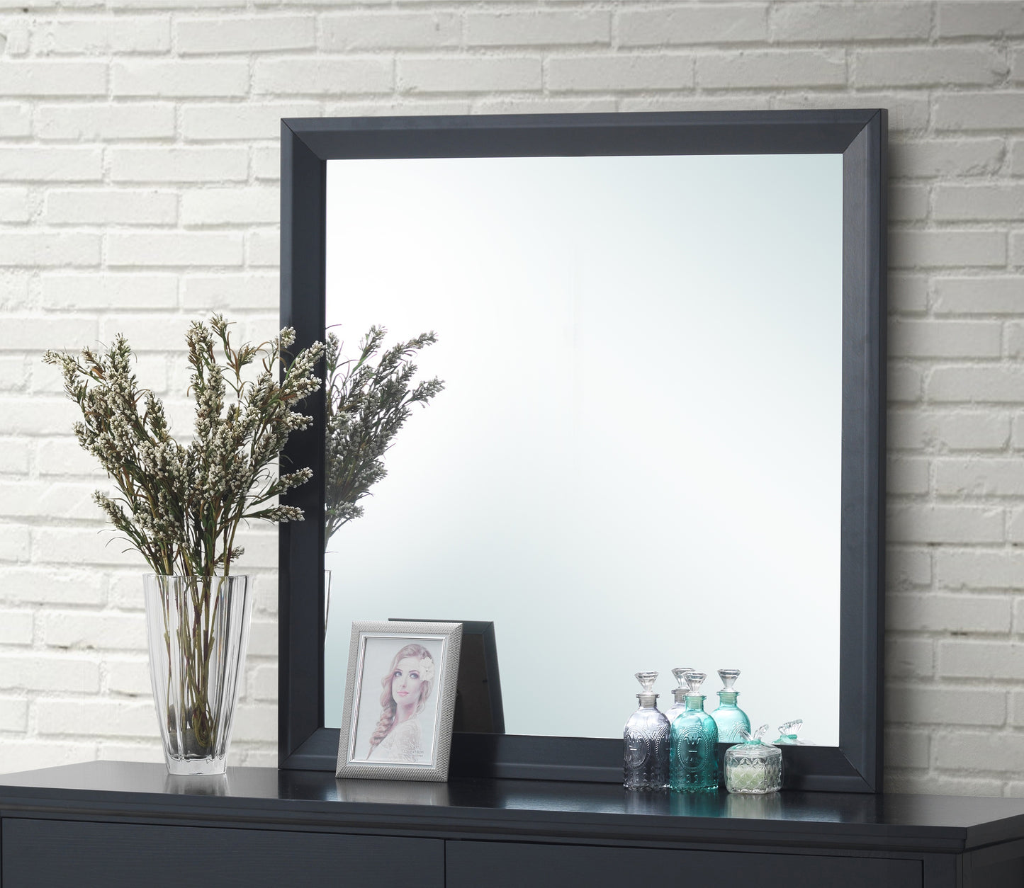 Dark gray framed wall mirror reflecting a bright room