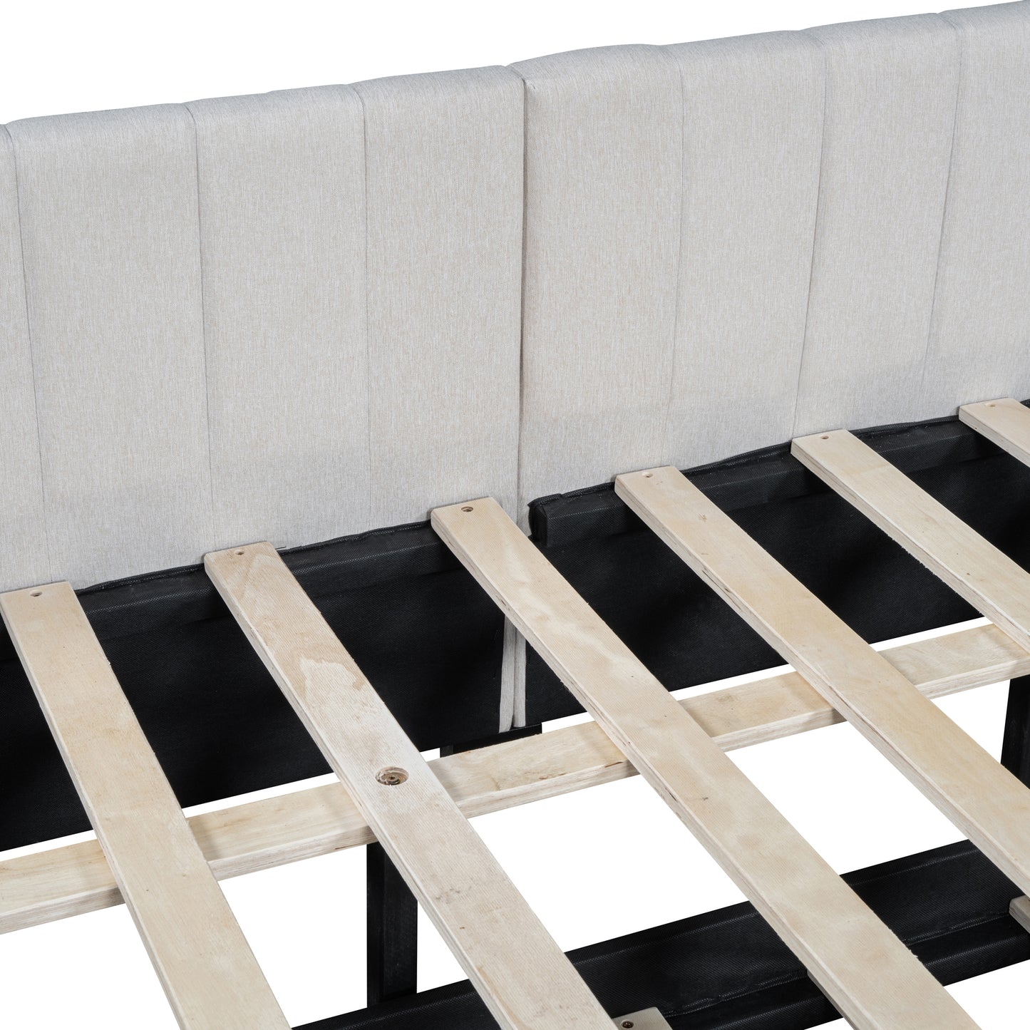 Closeup of a beige upholstered bed frame headboard with vertical stitching and wooden slats