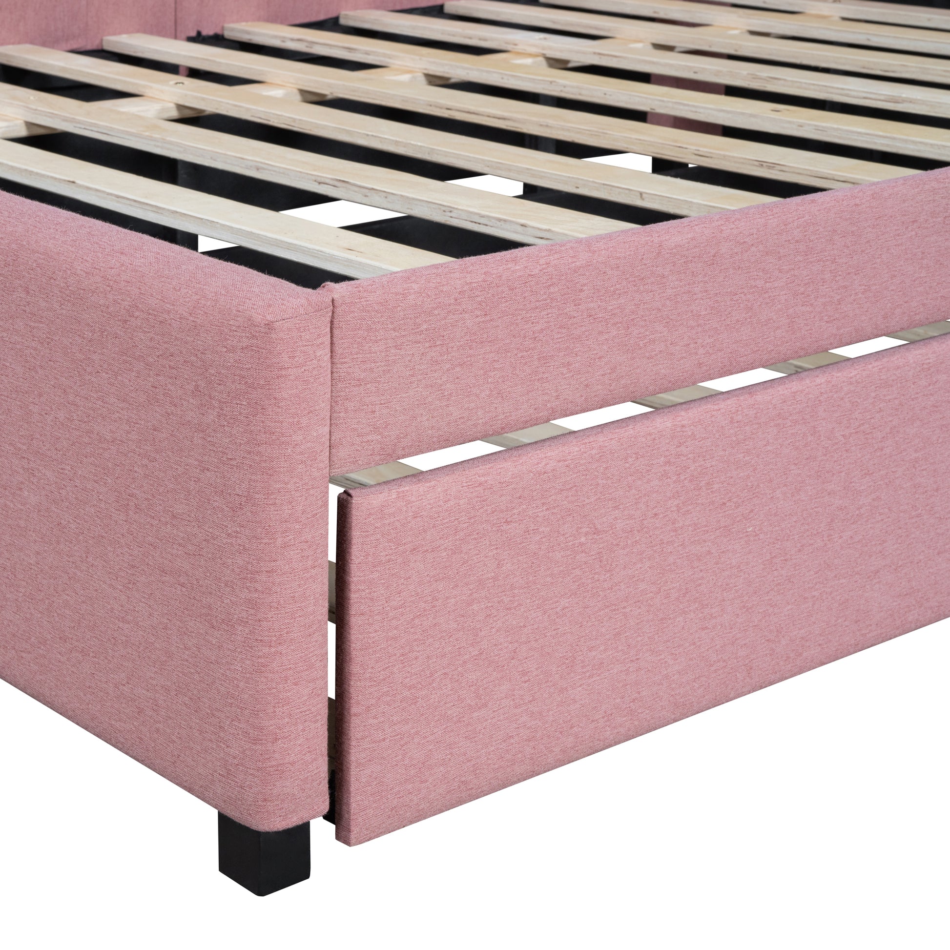 Closeup of a pink upholstered bed frame with a wooden slat support system