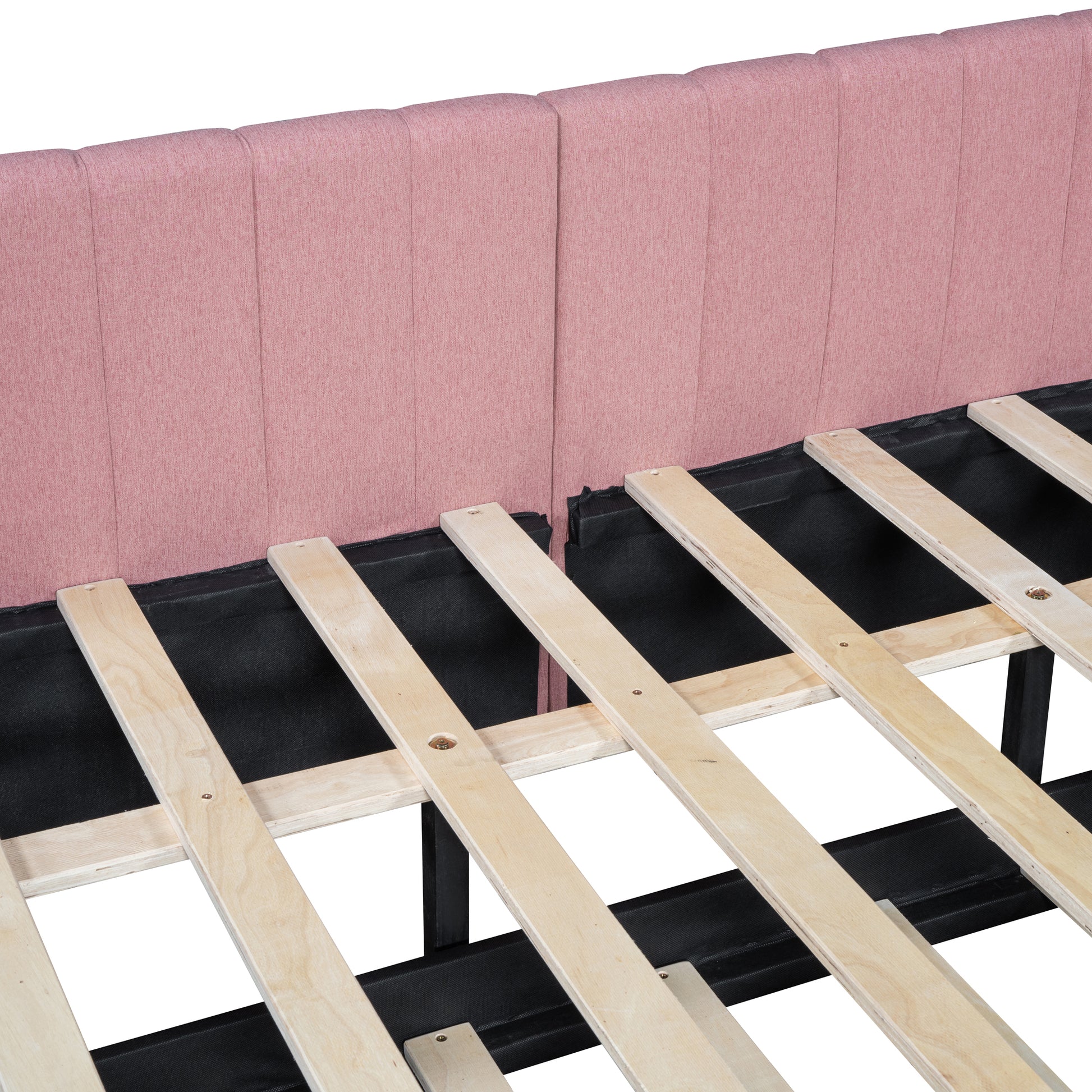 Closeup of pink upholstered headboard with vertical tufting