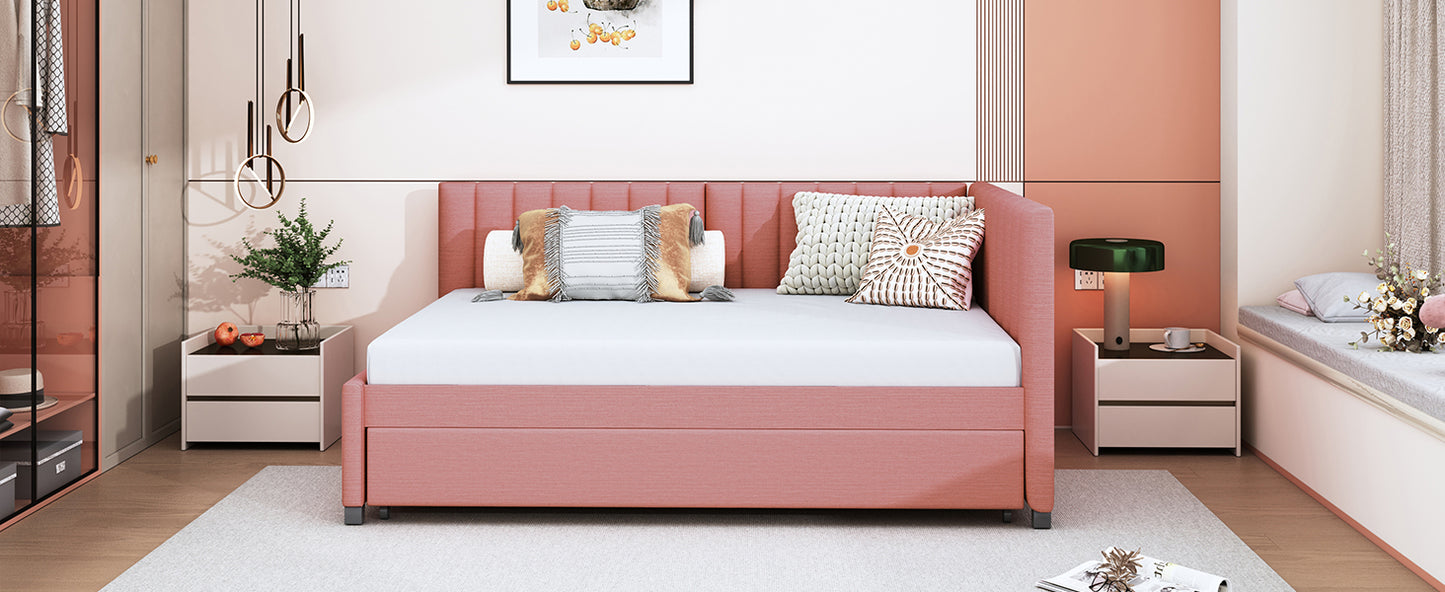 Pink upholstered daybed with a tufted headboard and pullout trundle