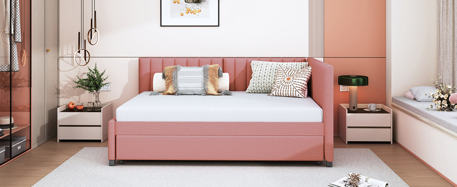 Pink upholstered daybed with a tufted headboard and pullout trundle
