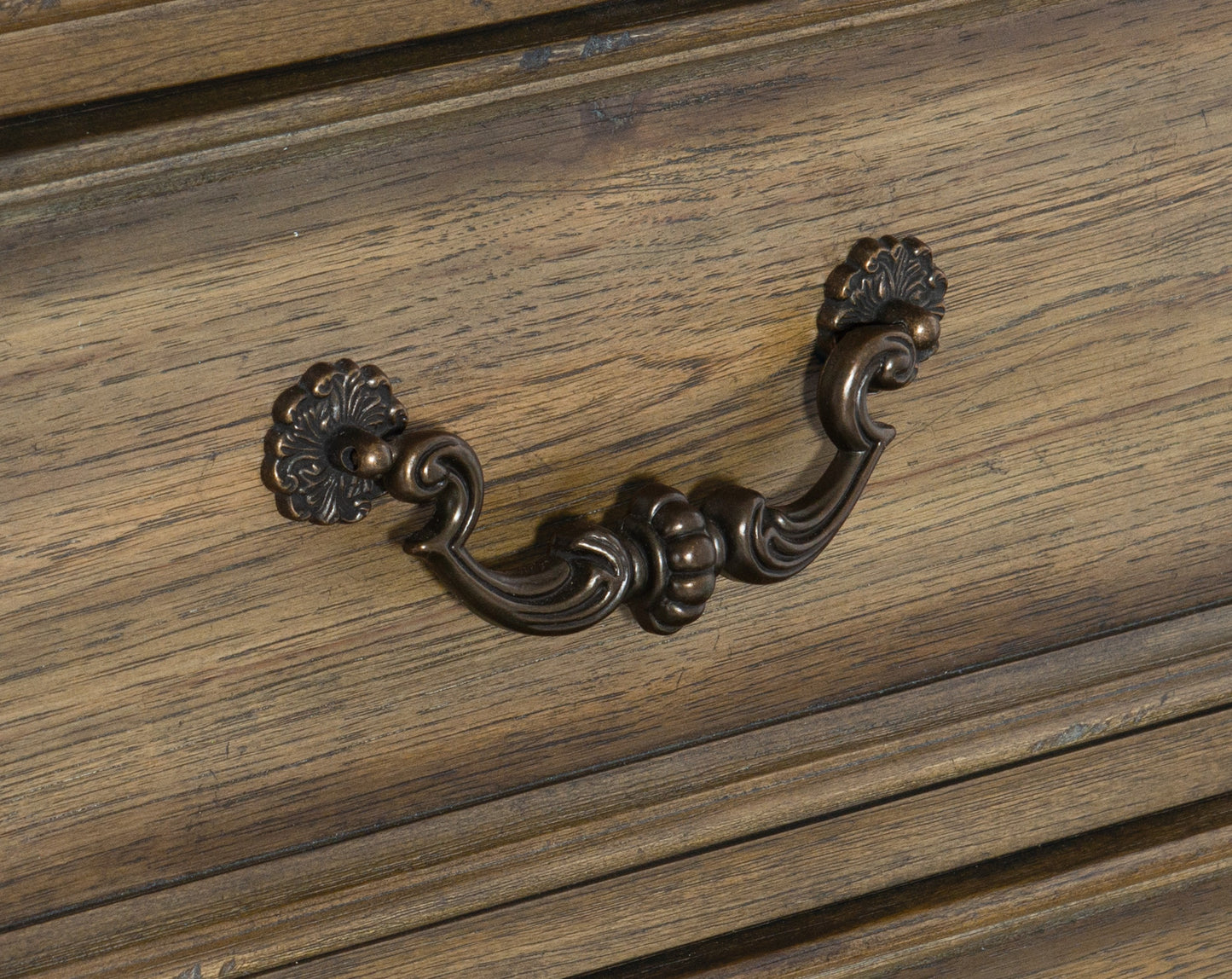Antique bronze drawer pull with ornate floral accents