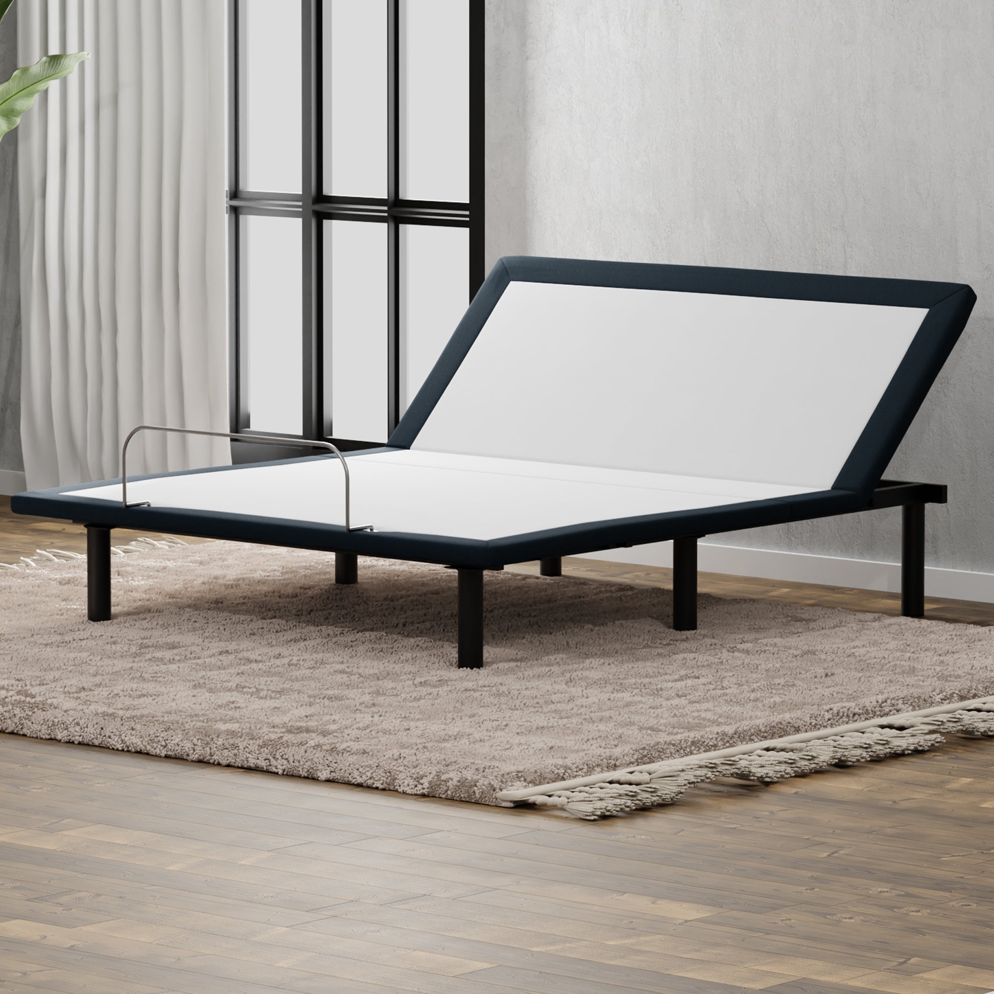 Dark blue upholstered adjustable bed frame with silver guardrail on shag rug