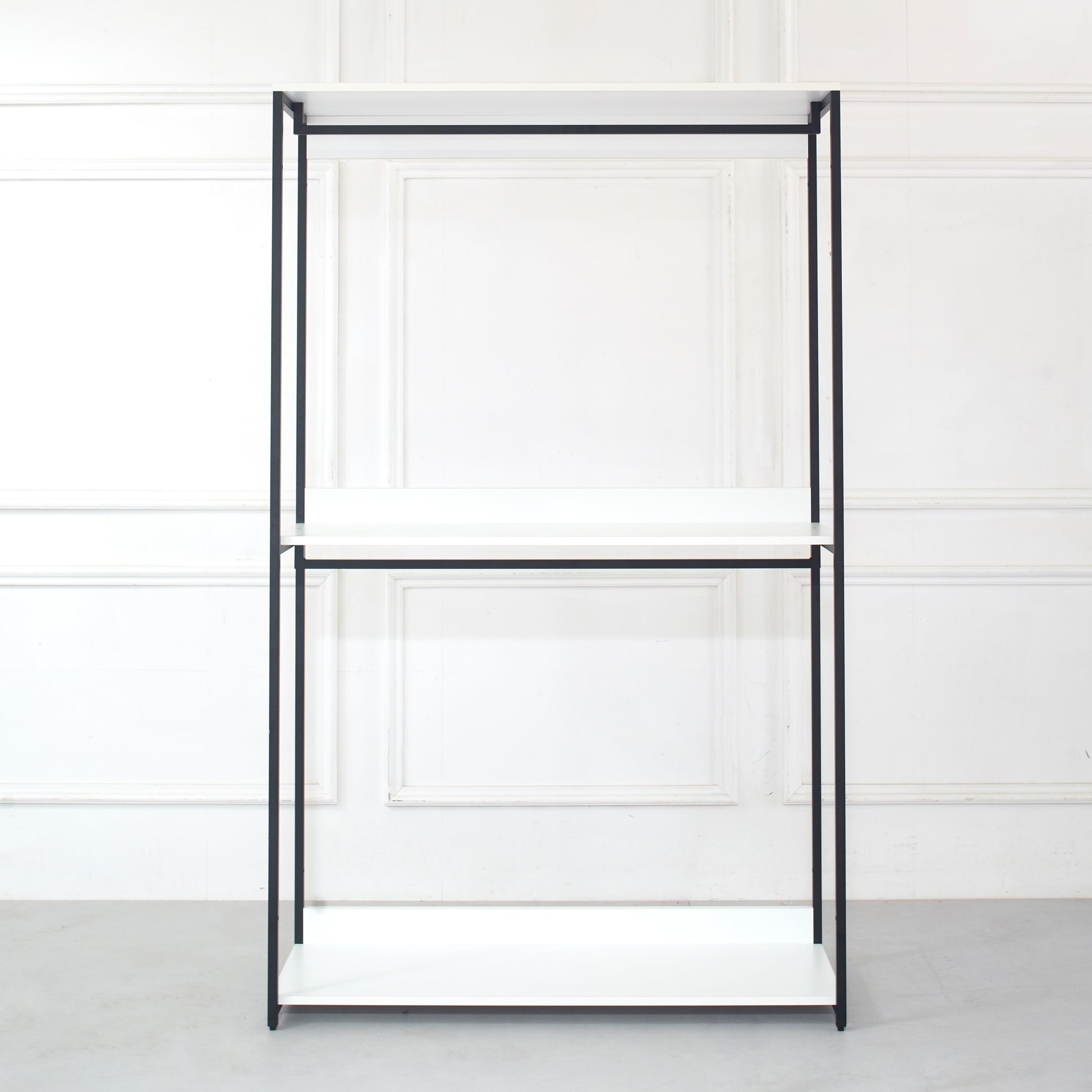 Minimalist black metal frame shelving unit with three white shelves