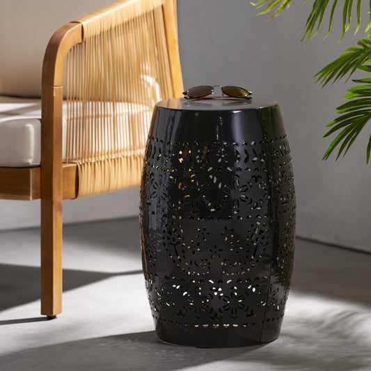 Black metal garden stool with intricate floral cutouts and a glossy finish