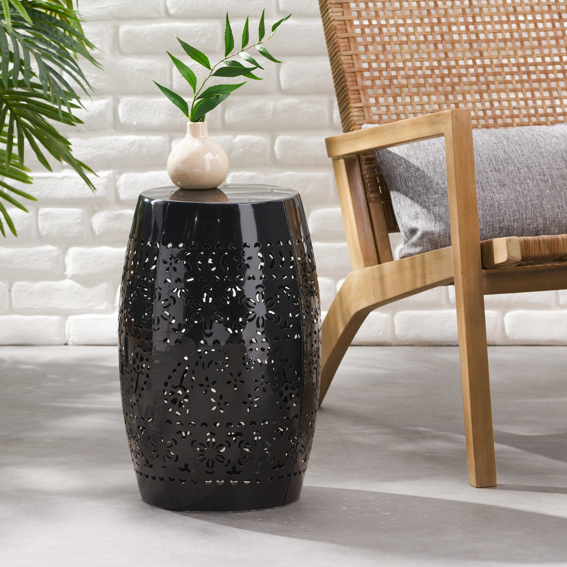 Black metal garden stool with intricate floral cutouts perfect for outdoor seating