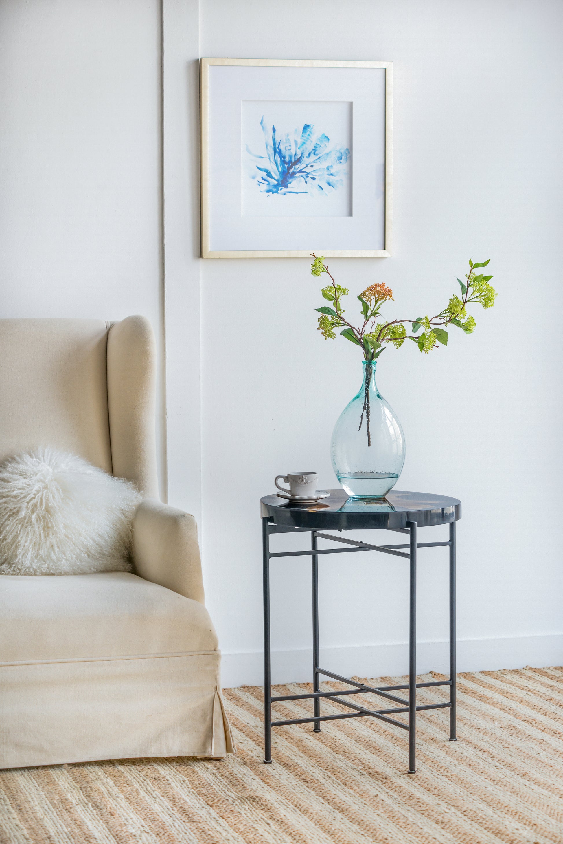 Framed abstract watercolor of blue coral on white background in a gold metal frame