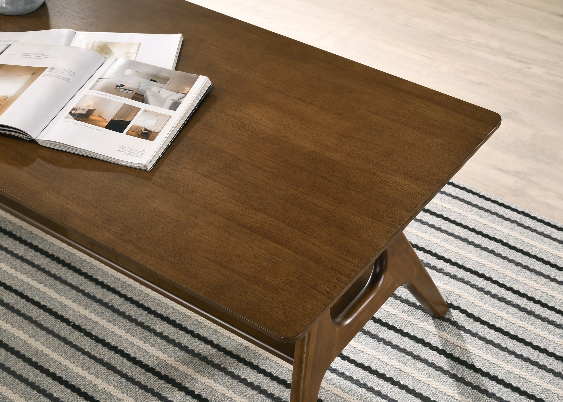 Dark wood coffee table with open magazine featuring midcentury modern design