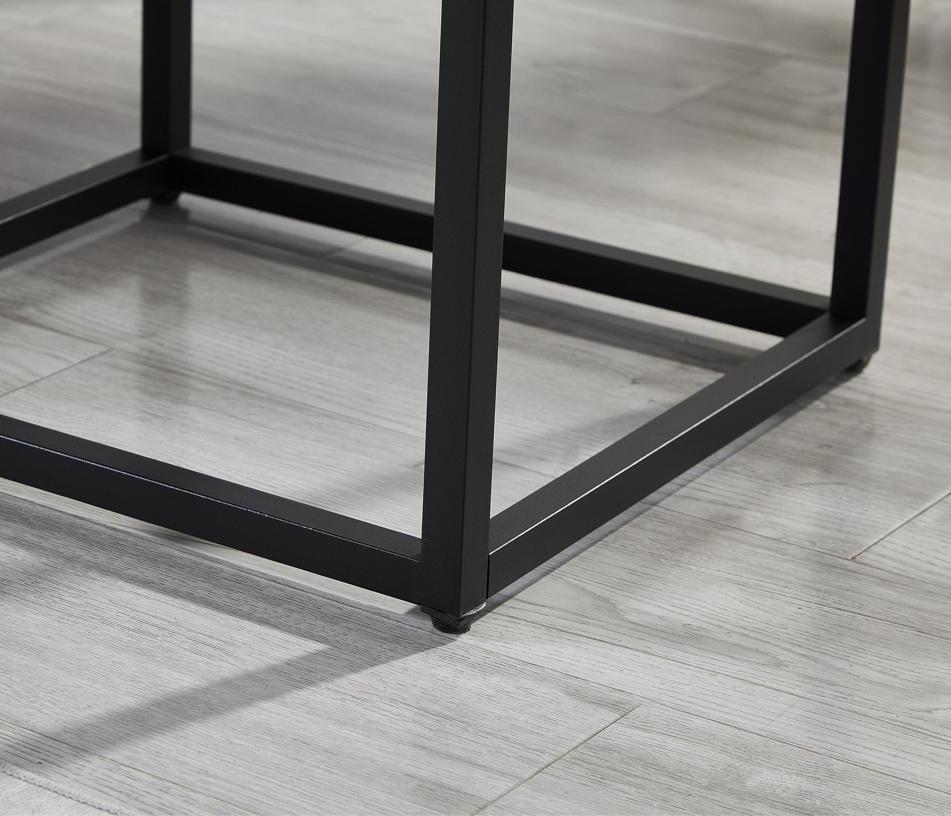 Black metal table legs with modern design on light wood floor