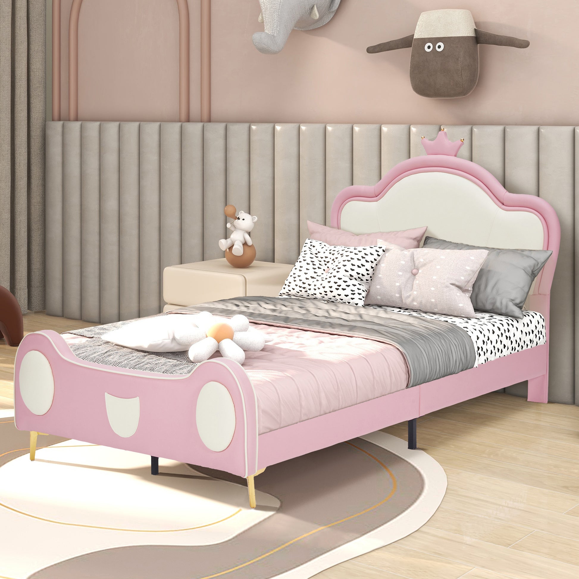Pink upholstered childrens bed with crown headboard and playful accents