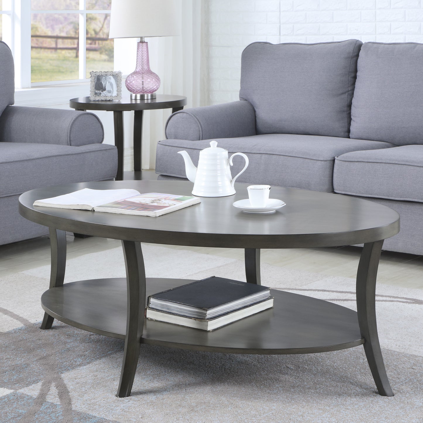 Dark gray oval coffee table with lower shelf modern design