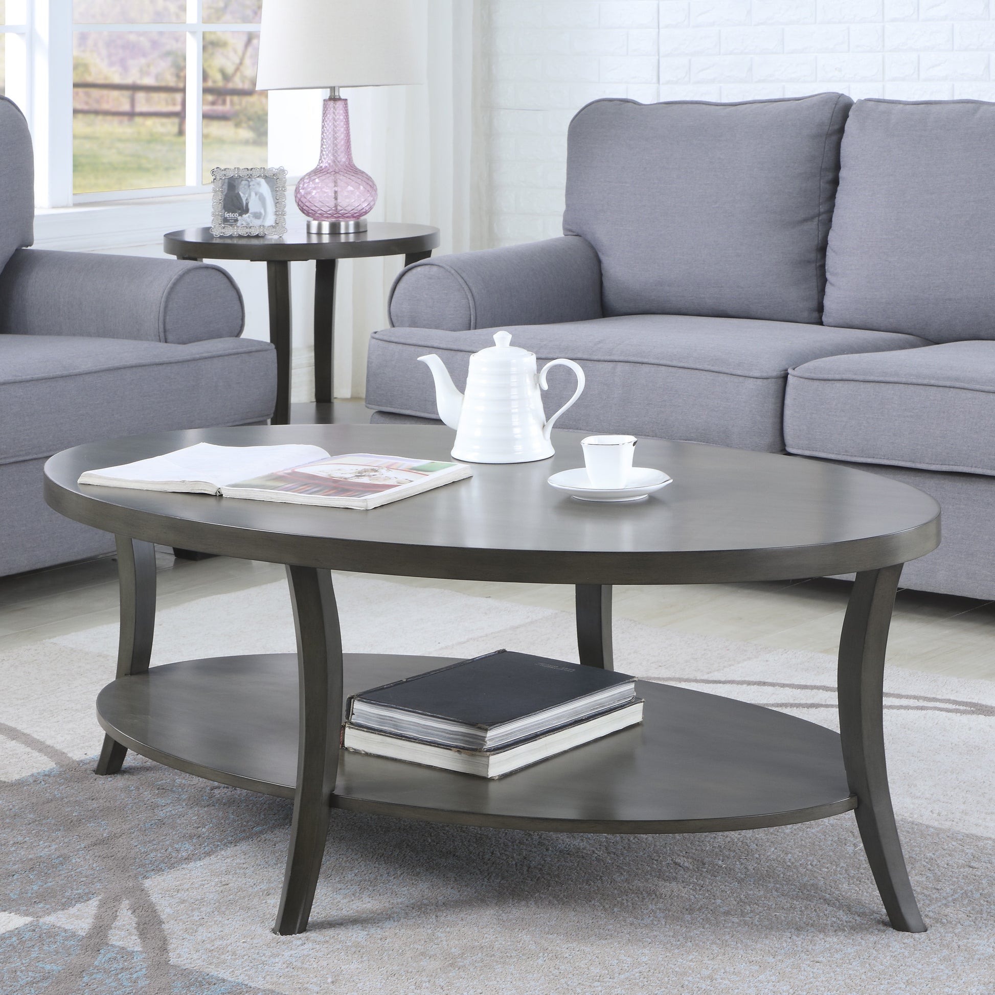 Dark gray oval coffee table with lower shelf modern design