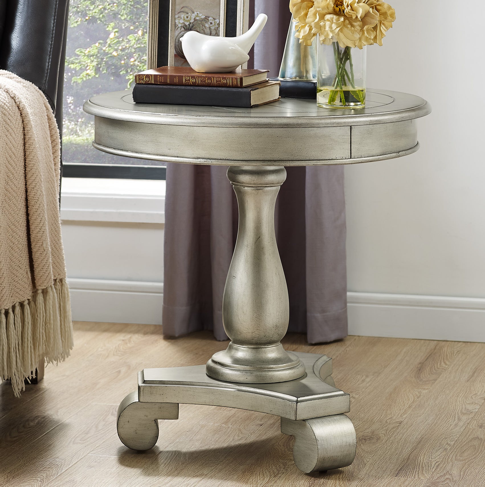 Antique silver round accent table with carved pedestal base and decorative drawer
