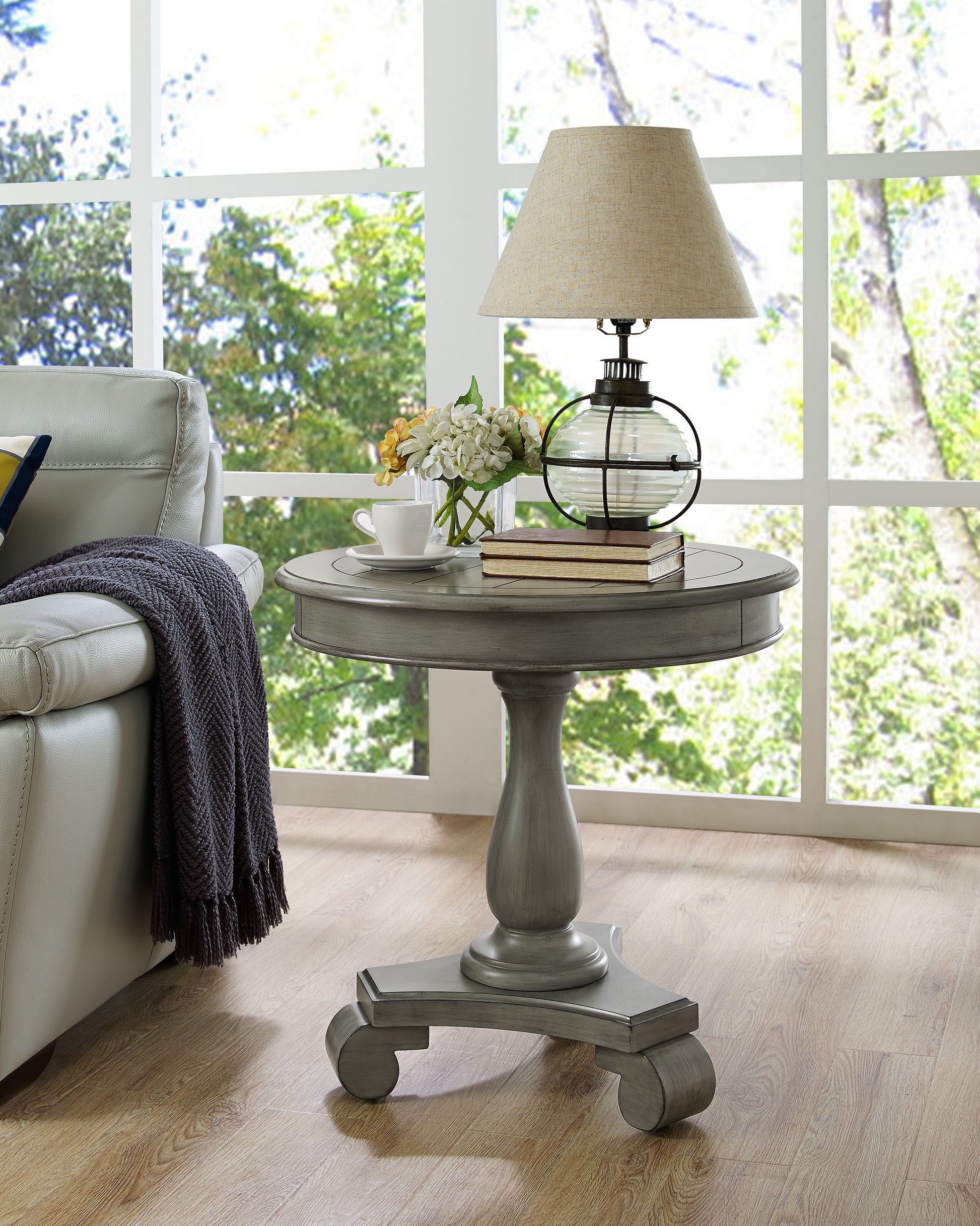 Distressed gray round end table with carved pedestal base and claw feet