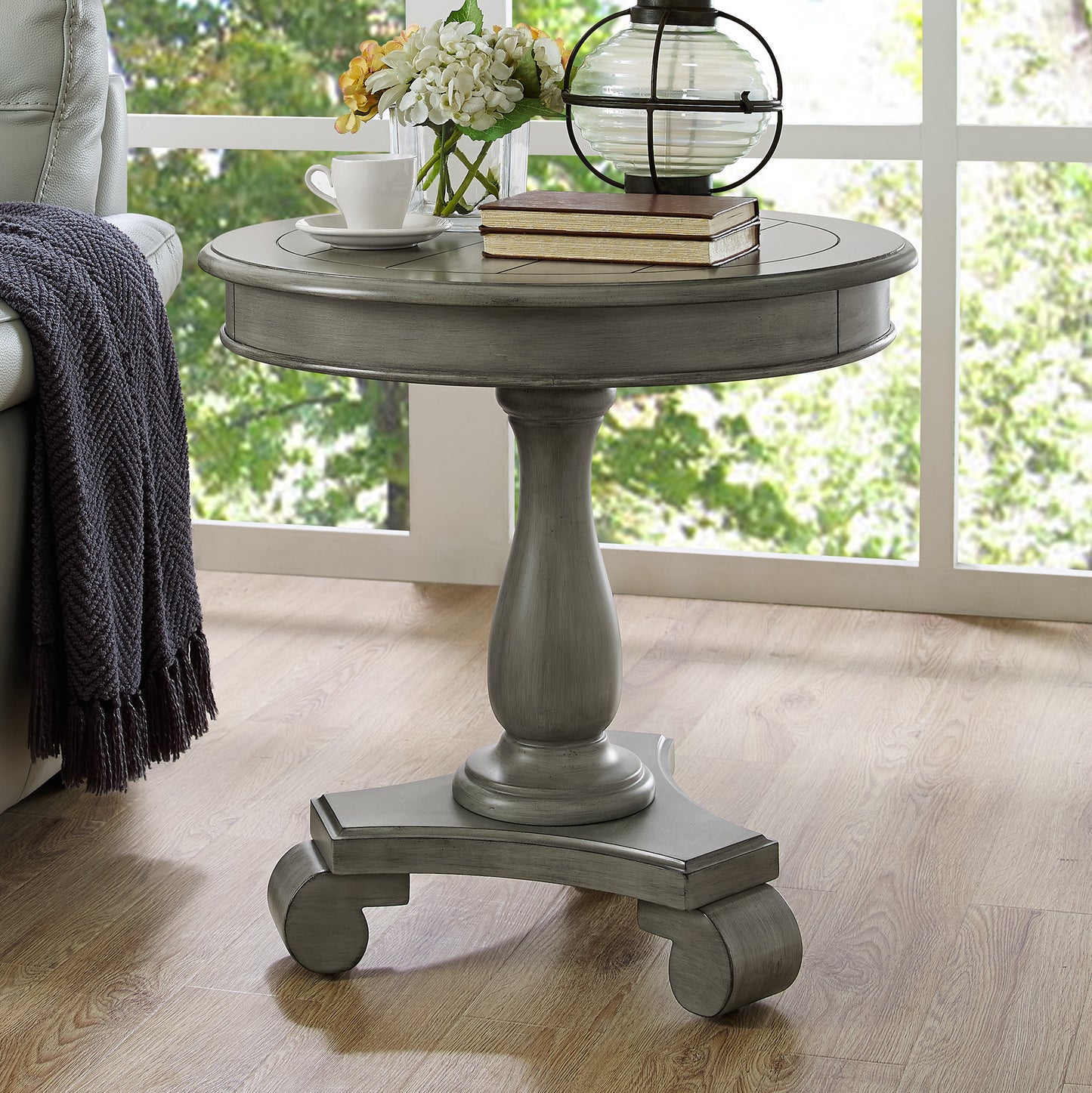 Gray distressed wood round accent table with a turned pedestal base and cabriole feet