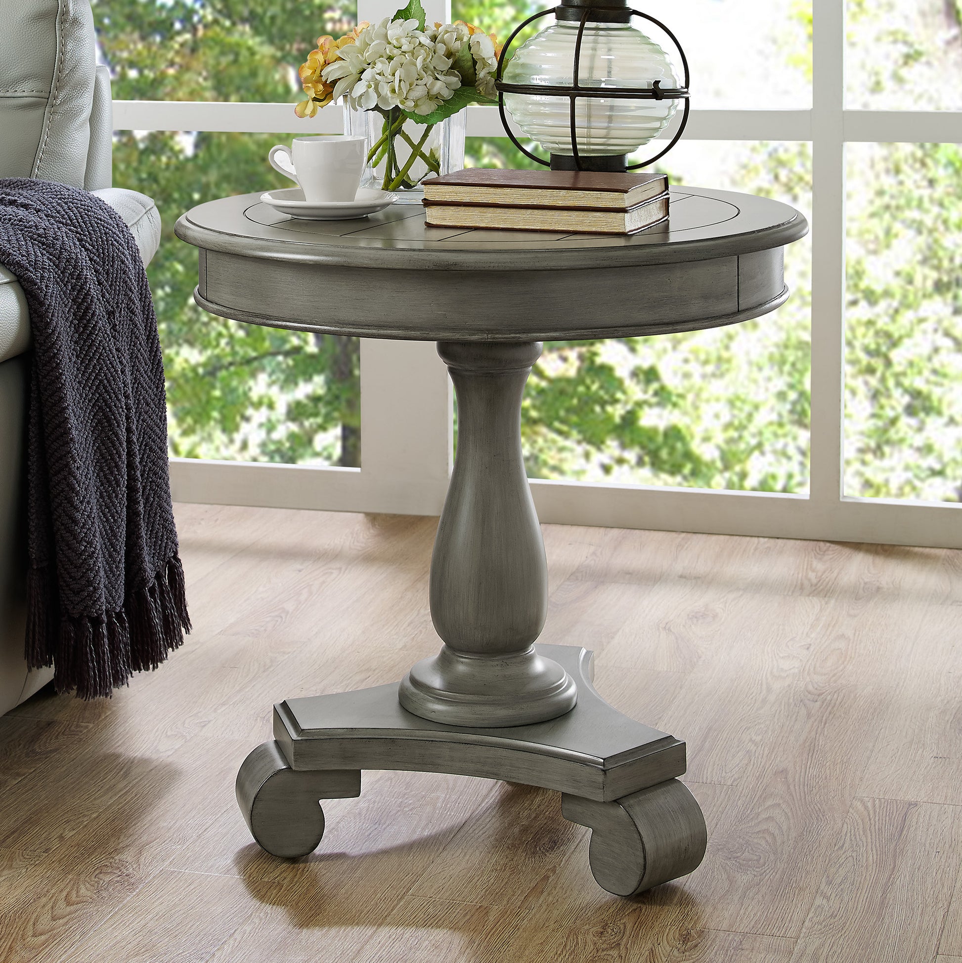 Gray distressed wood round accent table with a turned pedestal base and cabriole feet