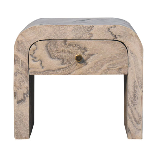 Curved travertine nightstand with brass knob and marblelike veining a modern bedroom accent