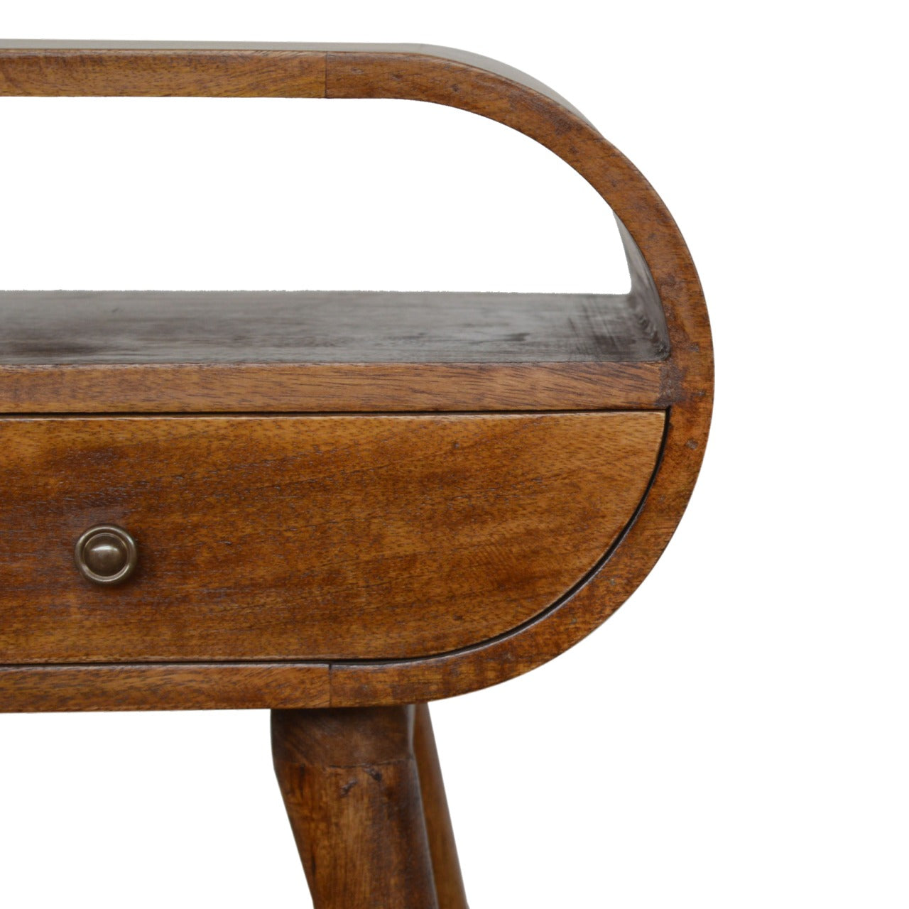 Close up of a wooden bedside table with a rounded drawer and brass knob