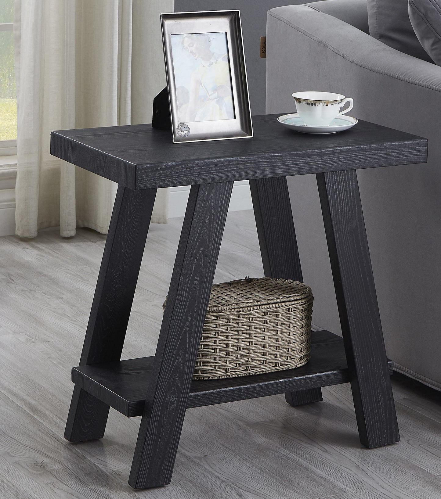 Dark wood side table with a woven basket and photo frame on top