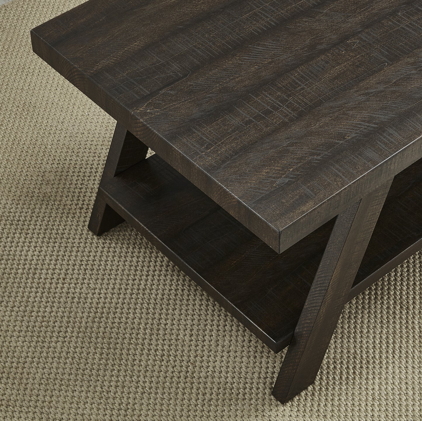 Dark brown distressed wood coffee table with a lower shelf and Xshaped legs