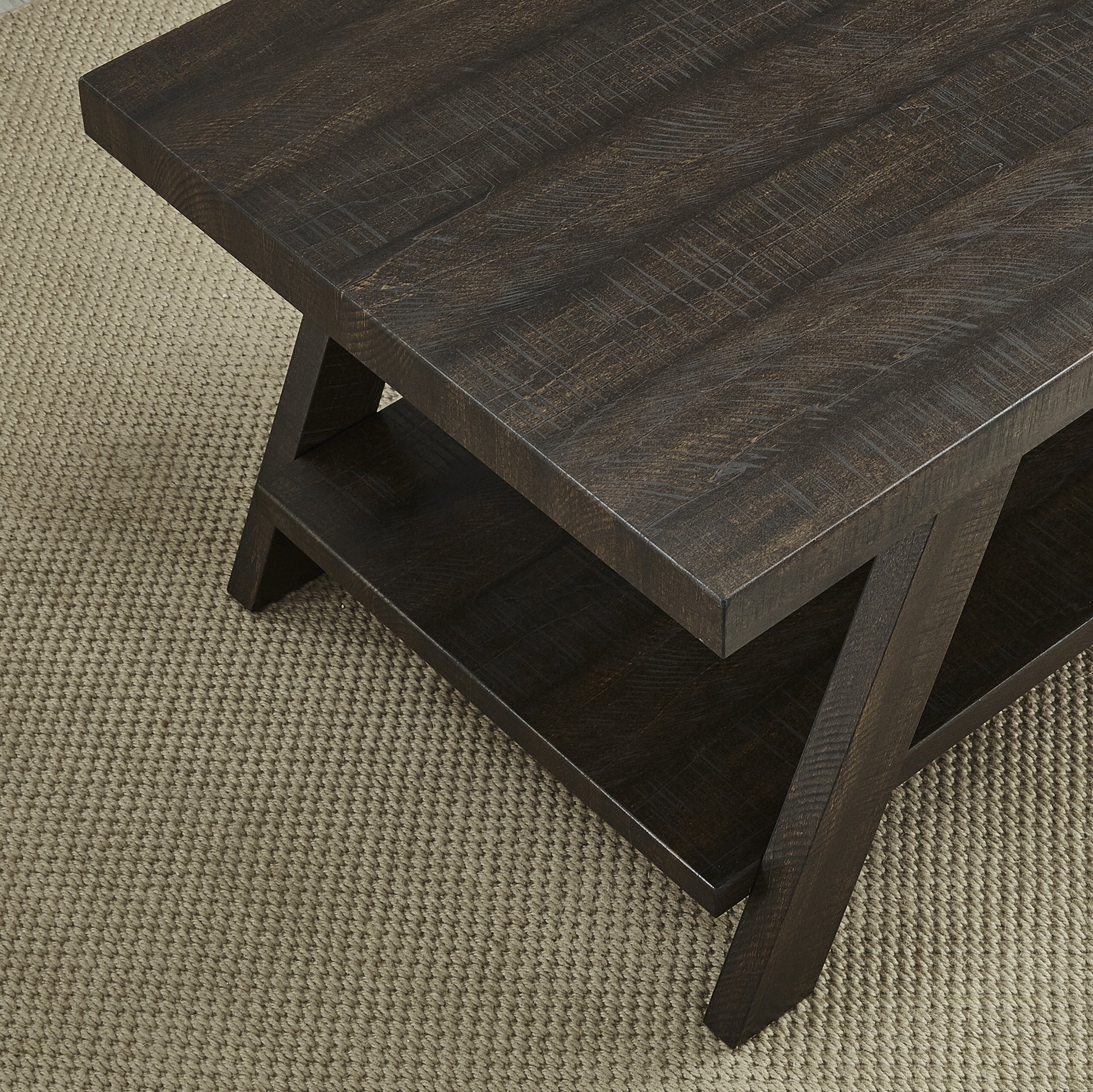 Dark brown distressed wood coffee table with a lower shelf and Xshaped legs