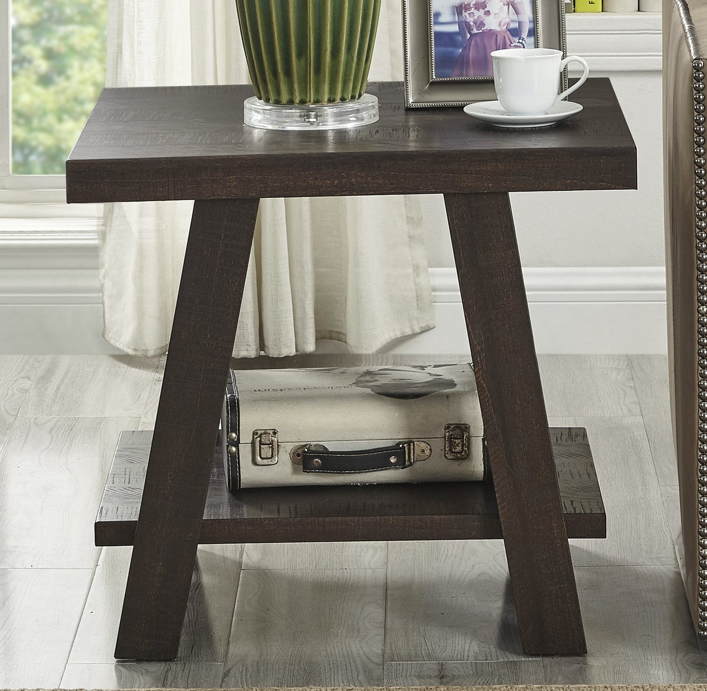 Dark wood end table with metal accents and decorative suitcase on lower shelf