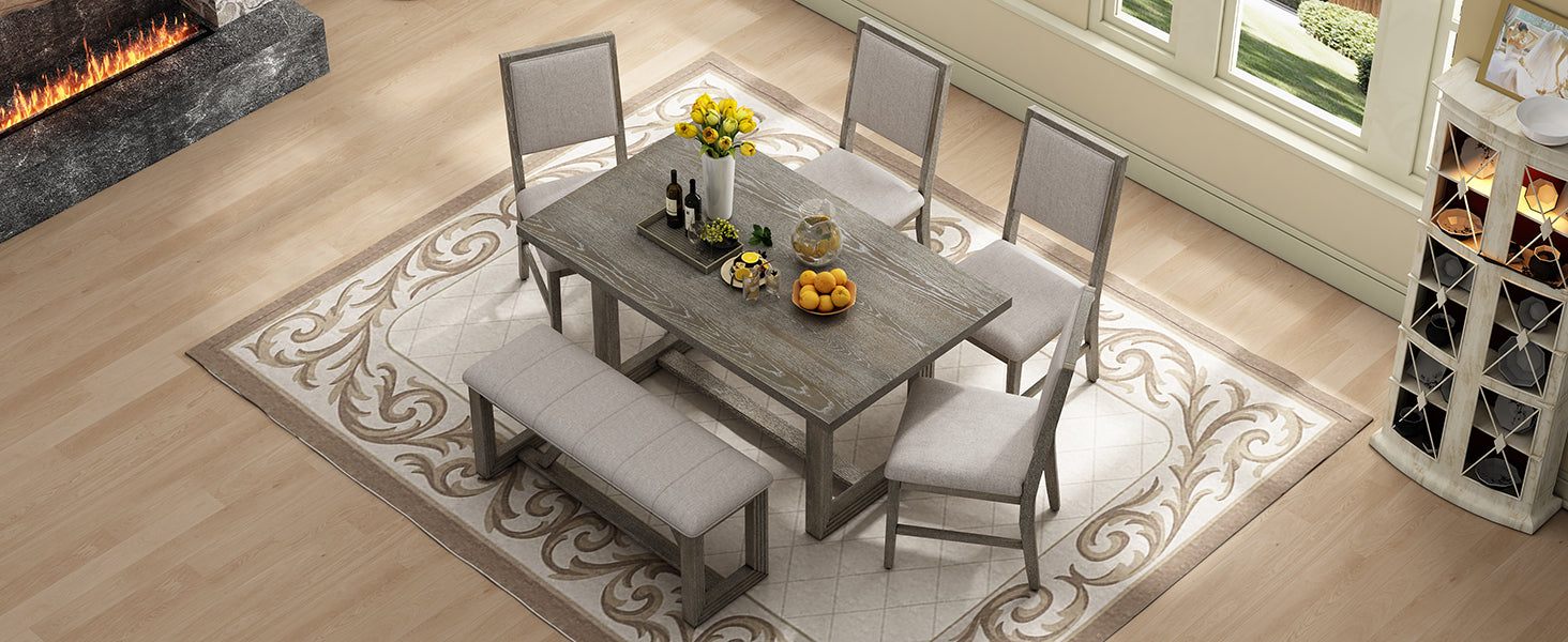 Gray wood dining table with bench and upholstered chairs