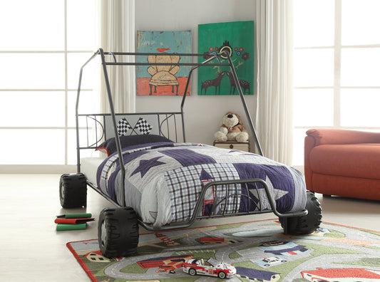 Race car bed frame in dark gray metal with black tire details and starpatterned bedding