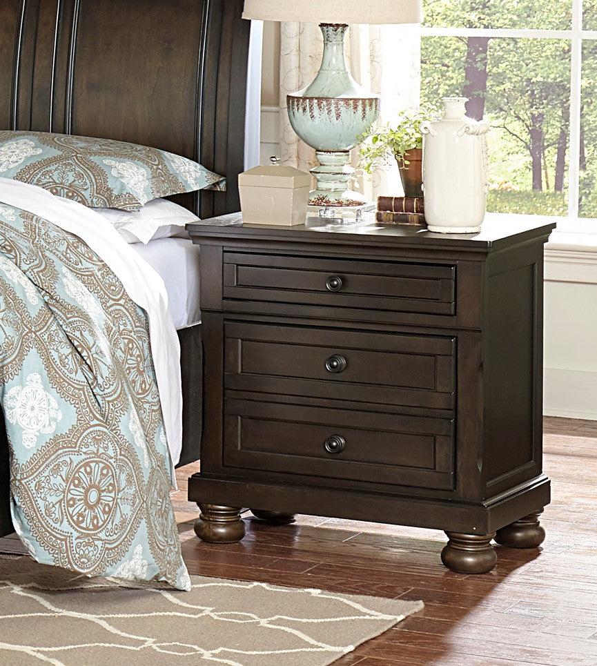 Dark wood threedrawer nightstand with decorative turned feet and ornate hardware